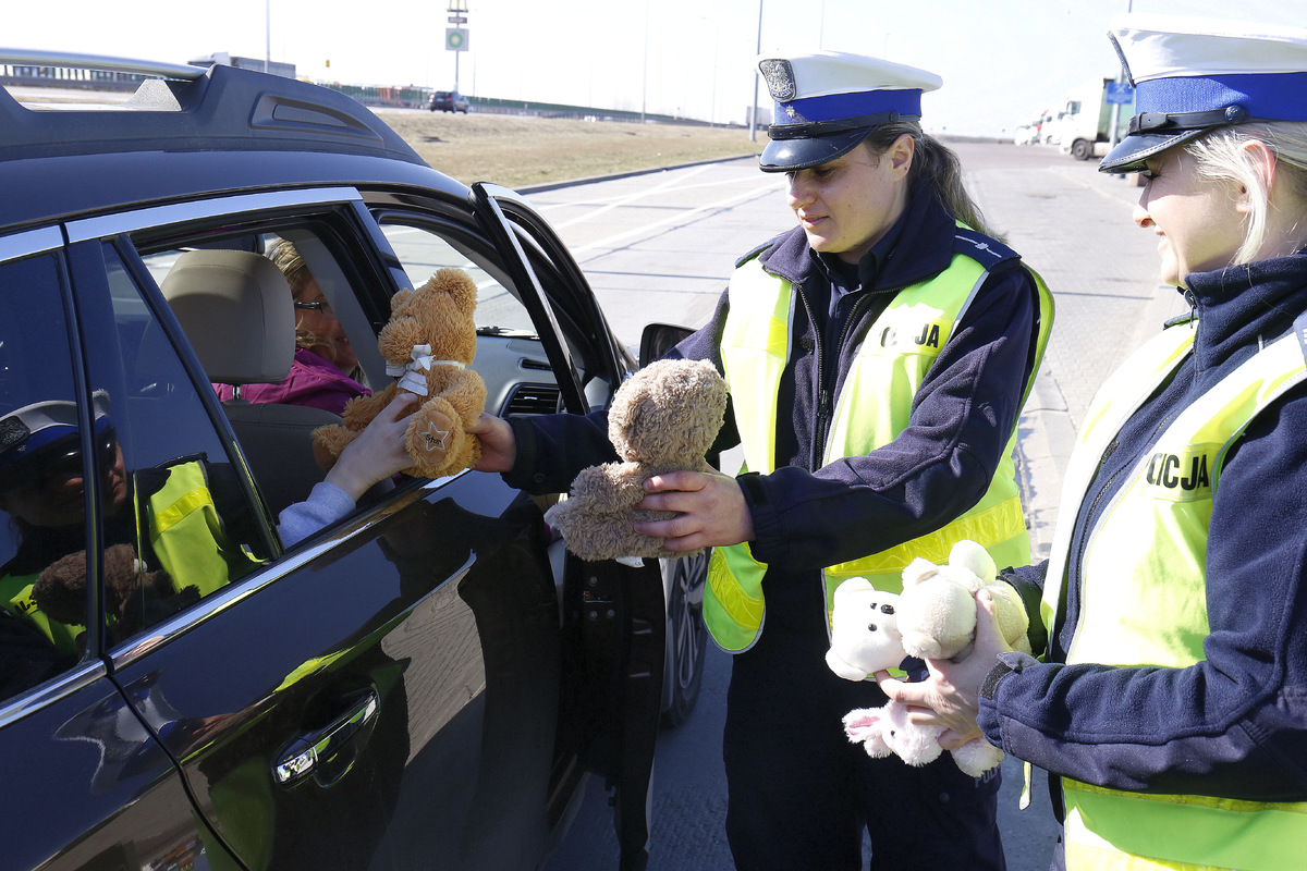 Policjantki wręczaja misie dzieciom z Ukrainy.