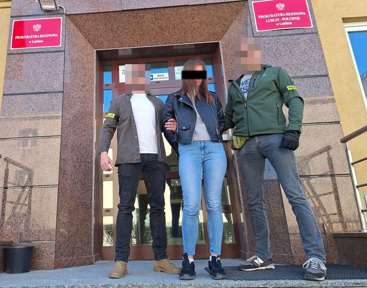 Policjanci prowadzą zatrzymaną kobietę do Prokuratury Rejonowej w Lublinie.