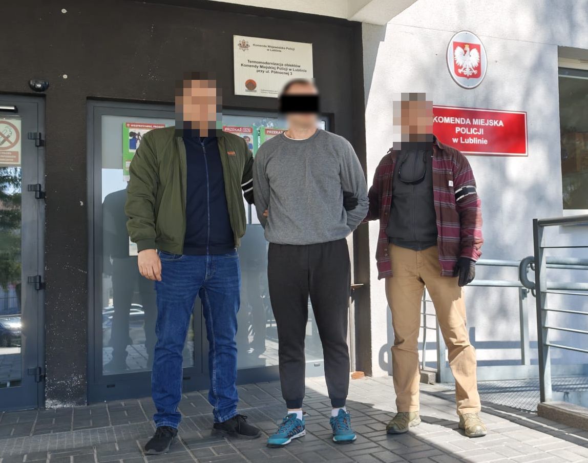 Policjanci wyprowadzają zatrzymanego mężczyznę z Komendy Miejskiej Policji w Lublinie.