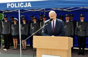 prezydent Żuk stoi przy mównicy i gratuluje policjantom