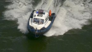 Ujęcie z drona, gdzie policyjna łódź płynie po zalewie zemborzyckim.