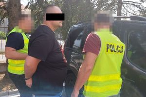 policjanci prowadzą zatrzymanego