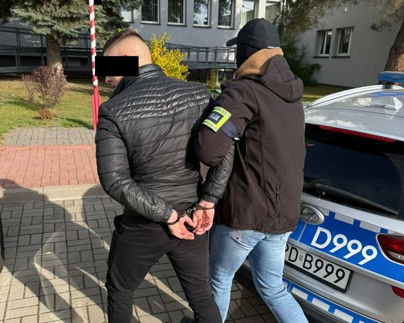 policjant prowadzi poszukiwanego