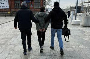 policjanci prowadzą zatrzymanego