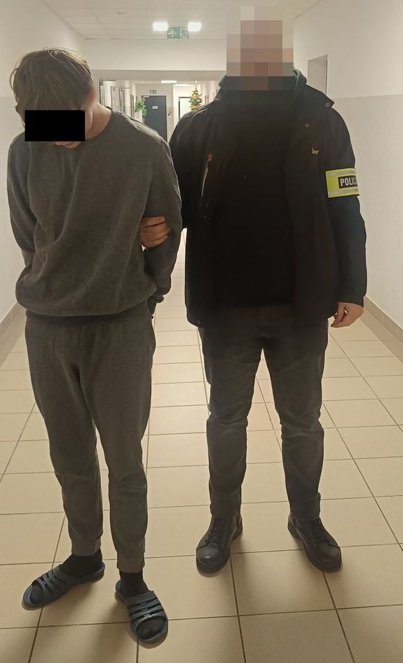 policjant podczas doprowadzenia zatrzymanego