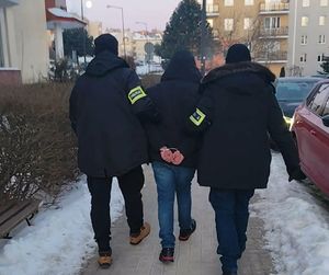 policjanci prowadzą zatrzymanego