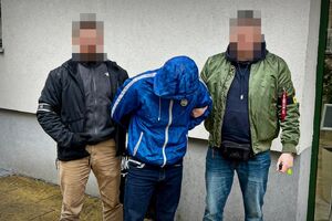 Policjanci prowadzą zatrzymanego mężczyznę.