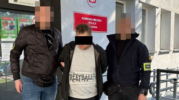 Policjanci prowadzą zatrzymanego mężczyznę