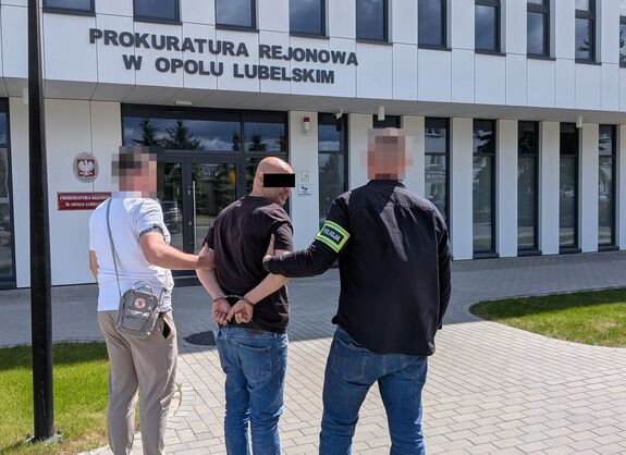 policjanci prowadzą zatrzymanego