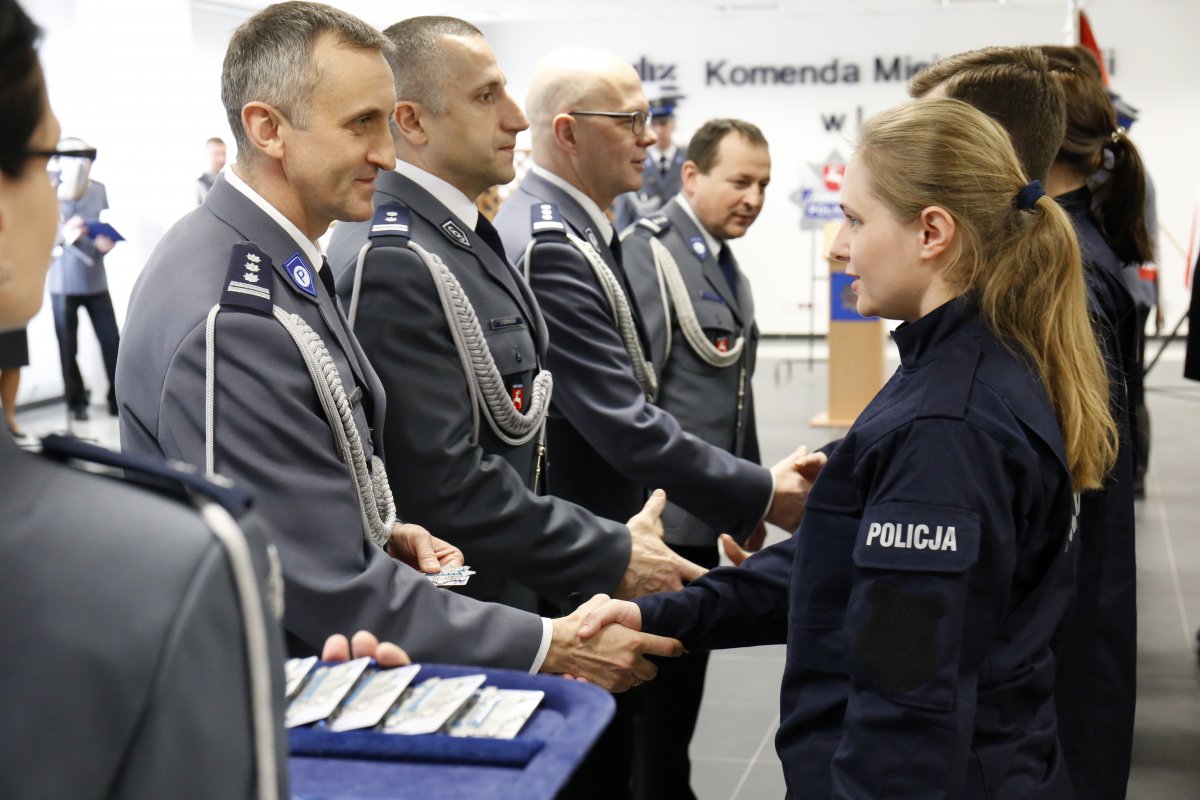 Policjantka otrzymuje legitymacje oraz gratulacje od Komendanta i jekgo zastępców.