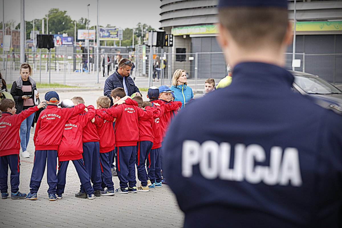 Policjant w tle dzieci idą na mecz.