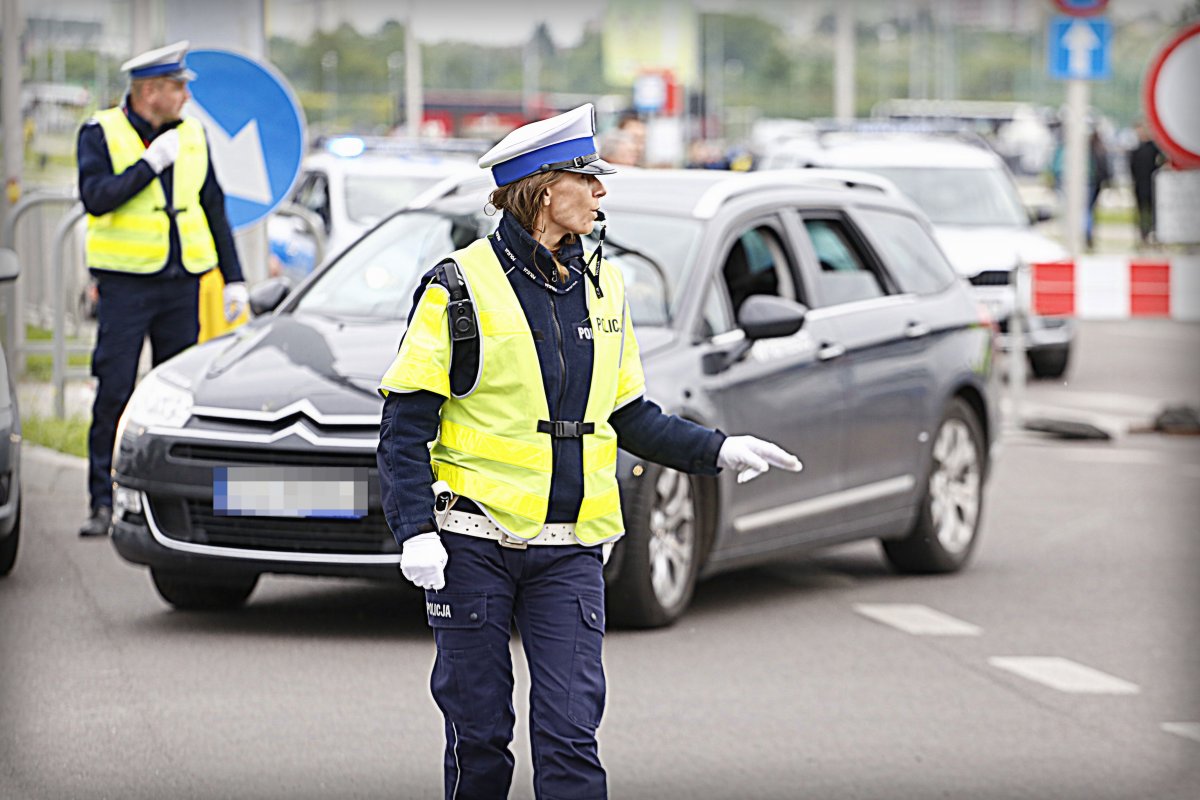 Policjantka reguluje ruchem na skrzyżowaniu.