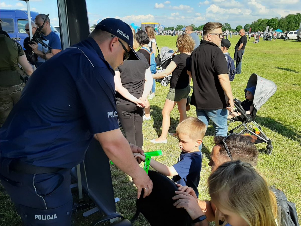 policjant rozdaje dzieciom odblaski