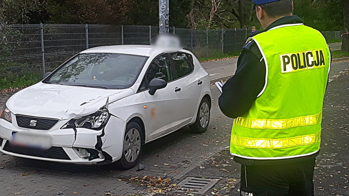 Policjant robi oględziny pojazu, który potrącił młodą kobietę.