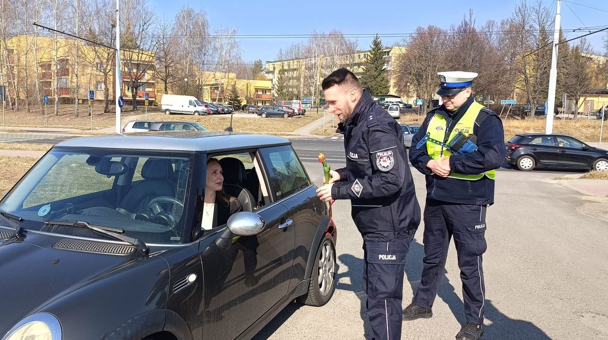 policjanci wręczają kierującej kwiatek