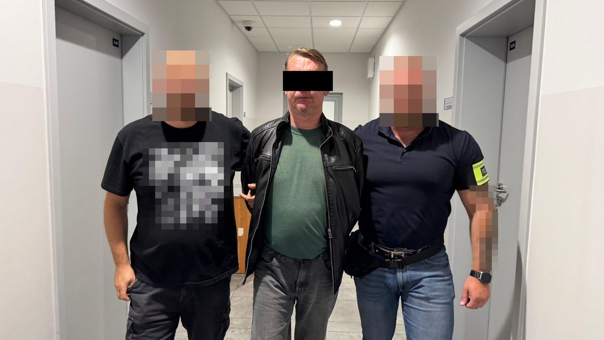 Policjanci prowadzą zatrzymanego mężczyznę.