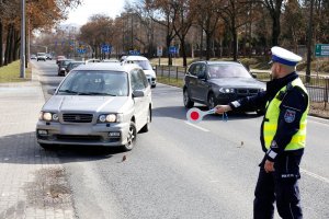 Policjant zatrzymuje auto do kontroli.