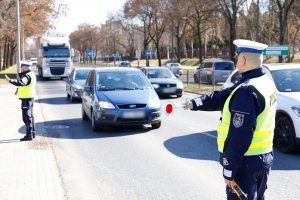 Policjant zatrzymuje do kontroli pojazd.