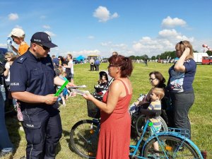 policjant rozmawia z uczestnikami festynu