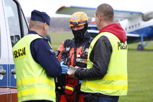 Policjanci rozmawiają z ratownikiem medycznym.