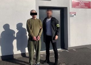 policjant z zatrzymanym mężczyzną