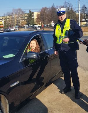 policjant wręcza kwiaty kierującej