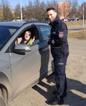 policjant wręcza kwiaty kierującej