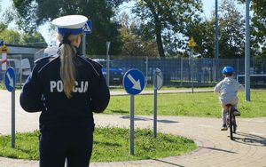 policjantka z dziećmi na miasteczku ruchu drogowego
