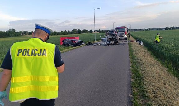 policjant na miejscu wypadku, w tle widać rozbite auta
