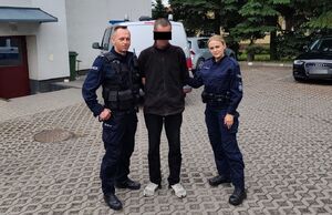 policjanci prowadzą zatrzymanego mężczyznę