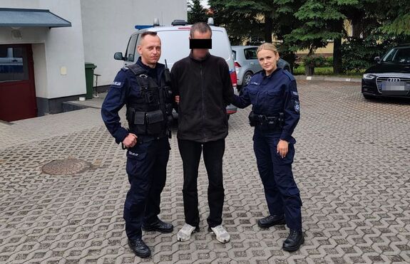 policjanci prowadzą zatrzymanego mężczyznę