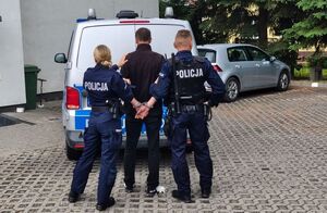 policjanci prowadzą zatrzymanego mężczyznę