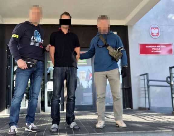policjanci prowadzą zatrzymanego mężczyznę
